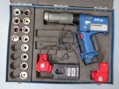 une boîte contenant des outils, notamment une perceuse, un tournevis, des clés et d'autres outils