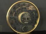 a black and gold clock sitting on a black table