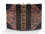 un livre ouvert, avec une couverture noire et des bordures dorées