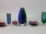 cinq vases en verre de couleurs différentes, disposés les uns à côté des autres