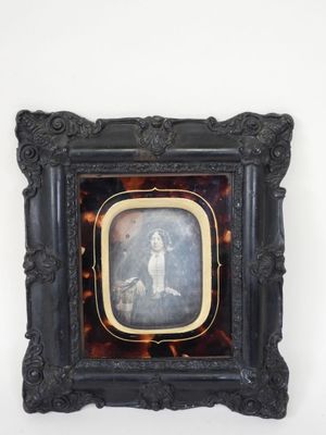 an old picture of a woman in a tortoise shell frame