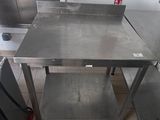 a stainless steel table in the middle of a kitchen