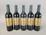 quatre bouteilles de vin sont alignées sur une table