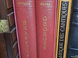 trois livres qui se trouvent sur une étagère d'une bibliothèque