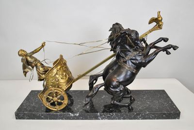 statue of a man on a horse pulling a chariot with a man on a horse