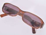 des lunettes de soleil posées sur une surface blanche, avec des verres violets