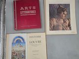 trois livres posés sur une table à côté d'une valise