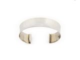 a close up of a silver cuff bracelet on a white background