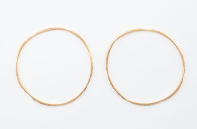 une paire de boucles d'oreilles en or sur fond blanc
