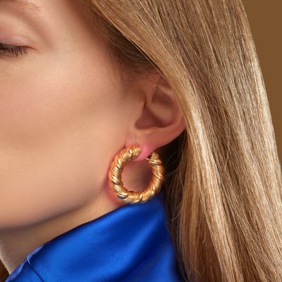 the woman is wearing a blue shirt and gold hoop earrings