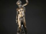une statue en bronze représentant un homme tenant une harpe, posée sur un socle en bois
