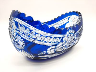 un bol en verre bleu posé sur une surface blanche