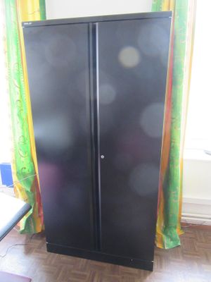 a black cabinet in the corner of a room next to a window