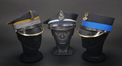 trois chapeaux sont empilés les uns sur les autres sur une surface noire