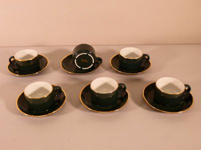 six black and white coffee cups and saucers sitting on a table