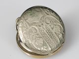 an antique silver pocket watch with an owl on the dial