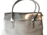 sac à main en cuir argenté sur fond blanc, avec une anse argentée