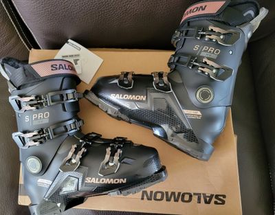 two pairs of ski boots sitting on top of a cardboard box