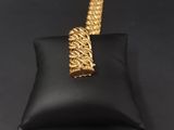 a close up of a gold chain on a black pillow