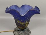 lampe en verre bleu en forme de fleur, avec un cordon jaune, sur fond blanc