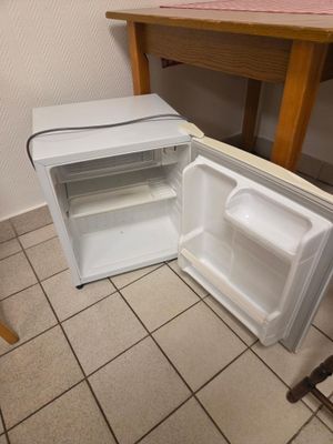 un réfrigérateur ouvert posé à même le sol dans une cuisine