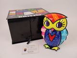 a colorful owl figurine sitting next to a black box