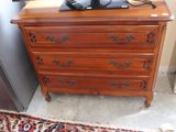 a wooden dresser with a television on top of it