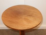 a small table with a wooden top on a carpeted floor