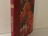 un livre à la couverture rouge posé sur une table blanche