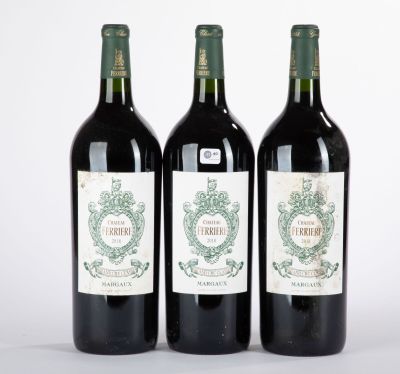trois bouteilles de vin posées les unes à côté des autres sur une surface blanche