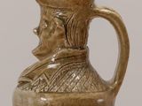 a brown pitcher sitting on top of a wooden table