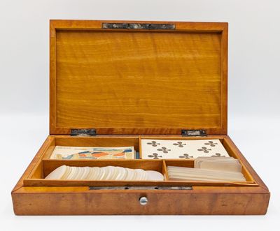 une boîte en bois contenant des cartes, posée sur une surface blanche