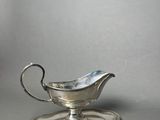 silver plated gravy with a saucer on top of it