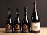 quatre bouteilles de vin sont alignées sur une table