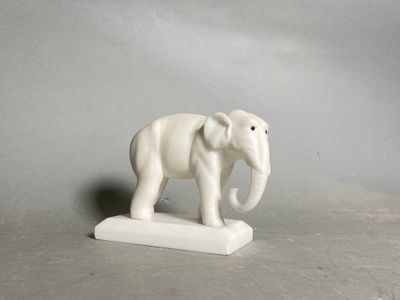 statue of an elephant on a white base against a gray background