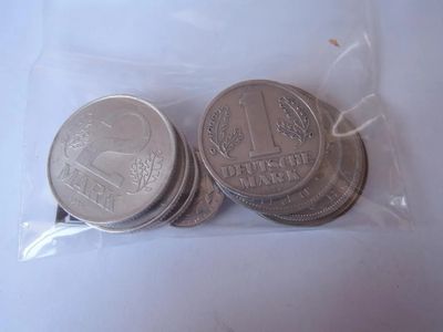 four coins in a plastic bag on a white surface