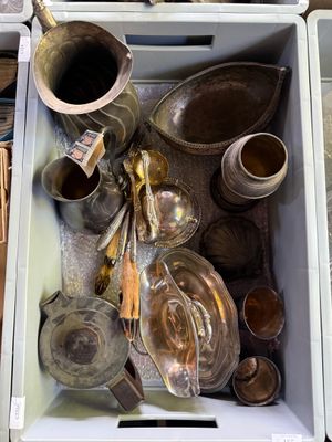 une boîte blanche remplie de nombreux couverts, posée sur une table