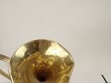 a gold trumpet sitting on a table next to a pair of scissors