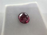 a close up of a red diamond on a white surface