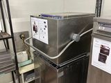 une machine qui se trouve dans une cuisine, à côté d'une étagère