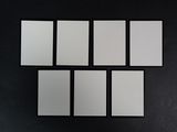 un mur noir sur lequel sont posés six carreaux carrés blancs