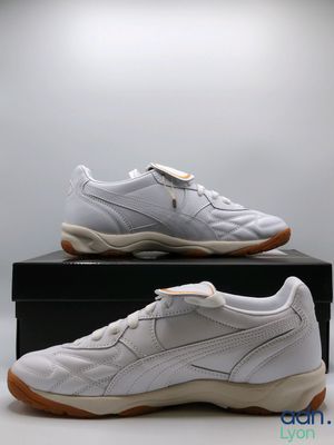 a pair of white sneakers sitting on top of a black box