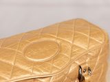 a gold purse sitting on top of a wooden table