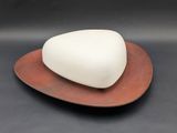 a white soap on a brown plate on a black surface