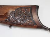 a close up of a rifle on a white surface