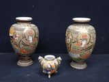 trois vases posés les uns à côté des autres sur une surface noire
