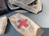 a brown bag with a red cross on it next to a brown purse