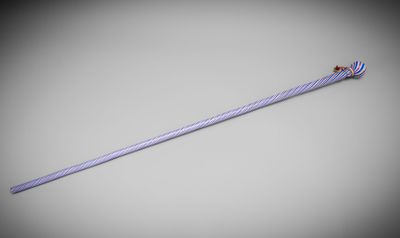 a close up of a long stick with a red handle on a gray background