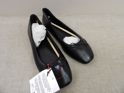 une paire de chaussures noires ornées d'un nœud blanc