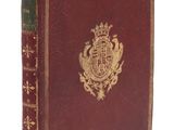 un vieux livre avec un emblème en or sur la couverture